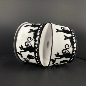 May include: Two spools of white ribbon with black silhouette cats printed on them. The ribbon is 2.5 inches wide.