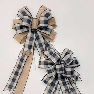 May include: Two black and white buffalo plaid bows with burlap tails. The larger bow has a 10-inch width and the smaller bow has a 6-inch width.