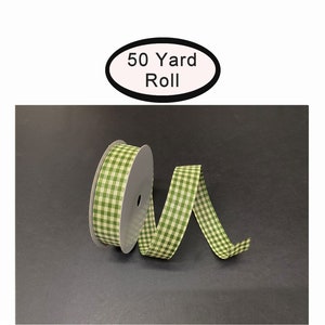 May include: A roll of 50 yards of green and white gingham ribbon. The ribbon is on a black background.