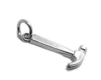 May include: A silver charm in the shape of a hammer. The charm has a loop at the top for attaching to a bracelet or necklace.