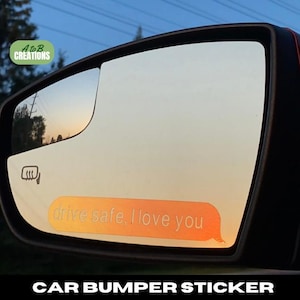 Può includere: Un adesivo per paraurti auto con una bolla di messaggio arancione e bianca che dice "guidare con attenzione, ti amo".