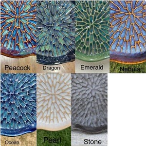 May include: A collection of seven circular ceramic plates featuring a radial, honeycomb-like texture. The color variations include Peacock, Dragon, Emerald, Nebula, Ocean, Pearl, and Stone, each labeled with its respective name below the plate.