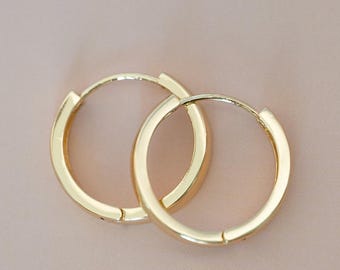 May include: Two gold-colored hoop earrings on a light pink background. The earrings are circular and have a simple, polished design. The text "Crush On Gold" is at the bottom of the image.