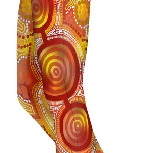 May include: Leggings with a vibrant, abstract design in shades of orange, yellow, and red. The pattern features concentric circles, dots, and lines, creating a unique and eye-catching look. These leggings are a stylish addition to any wardrobe.