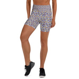 Peut inclure: Shorts de yoga taille haute avec un motif géométrique dans les tons de bleu, jaune et violet. Le short présente une large ceinture et une coupe ajustée, adaptée à diverses activités.