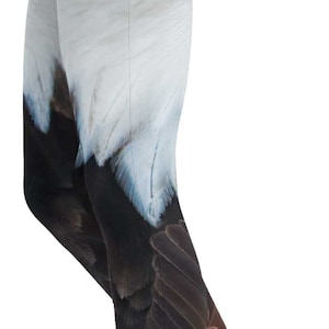 May include: Full-length leggings featuring a high-resolution photographic print of a bald eagle. The design displays the white feathers of the eagle's head and a piercing yellow eye near the hip, transitioning into dark brown feathers down the legs.
