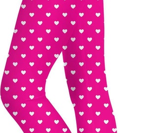 May include: Vibrant pink leggings patterned with small white hearts. The leggings are close-fitting and reach the ankles. The image shows the leggings from the waist down.