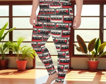 May include: Leggings patterned with repeating retro cassette tapes in red, black, and white. The leggings feature the text "New Wave" and "Rock & Roll" on the cassette tape designs. The leggings are form-fitting and made of a soft material.