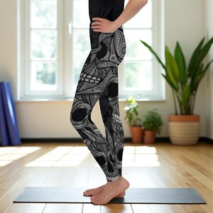 Peut inclure: Legging noir et blanc avec des motifs de crânes et des motifs floraux et géométriques complexes. Le legging est taille haute et de longueur totale. Le motif de crâne est bien visible sur le devant.