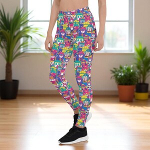 May include: Vibrant leggings with a repeating pattern of colorful cartoon characters in shades of blue, yellow, pink, and green. The leggings are form-fitting and made of a stretchy material.