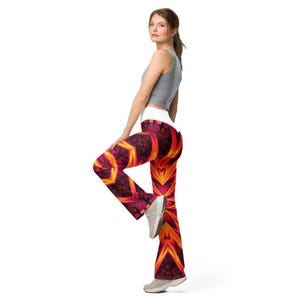Könnte beinhalten: Hoch taillierte Yogahose mit einem lebendigen, kaleidoskopischen Muster in feurigen Orange-, tiefen Rot- und Magentatönen. Die Leggings haben einen breiten weißen Bund und ein ausgestelltes Bein mit einem komplexen geometrischen Design.