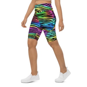 May include: Bright, multi-coloured zebra print cycling shorts. The shorts display a rainbow of colours including pink, yellow, green, blue, and black. The shorts are knee-length and appear to be made of a stretchy material.