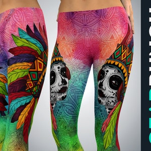 Może przedstawiać: Legginsy z tłem w żywy, wielokolorowy wzór mandali oraz grafiką przedstawiającą twarz pomalowaną w stylu sugar skull, noszącą kolorowy pióropusz. Wzór zawiera czerwone, żółte, zielone i niebieskie pióra.