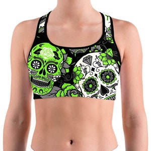 May include: Black sports bra featuring a vibrant sugar skull design. The bra showcases a neon green and white skull with floral accents, set against a black background. The design includes gray and white floral patterns.