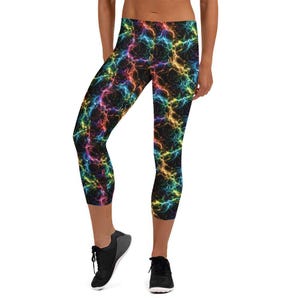May include: Capri-length leggings with a black background and a vibrant, multicolored lightning bolt pattern. The leggings are form-fitting and reach just below the knees. The design features shades of red, yellow, blue, and green.