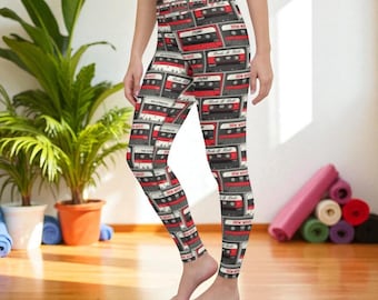 May include: High-waisted leggings featuring an all-over repeating pattern of vintage cassette tapes. The design includes black and red cassette tapes with white labels and text, set against a light grey background, covering the entire leg length.