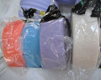 May include: Four rolls of tissue paper in various colors, including orange, blue, purple, and white. The rolls are wrapped in clear plastic and are ready for use.