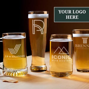 May include: Four different beer glasses filled with beer and foam. Each glass has a unique logo etched on it, including "J&M Solutions", a stylized "R", "Iconic Web Design", and "Brennan Attorney at Law".