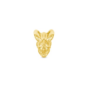 May include: A gold-colored pendant featuring a detailed, three-dimensional sculpture of a devil's head with horns.