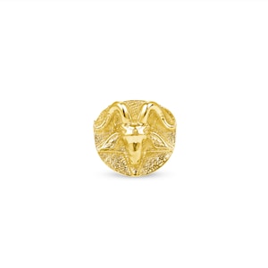 May include: A gold-colored ring with a detailed design of a goat's head.
