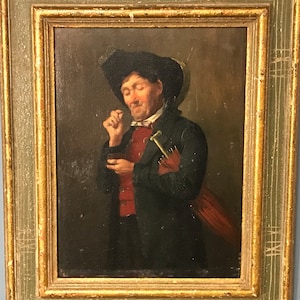 May include: A painting of a man in a dark coat and hat, holding a small object in his hand. He is looking down at the object, and his expression is thoughtful. The painting is set against a dark background.
