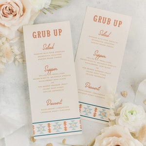 May include: Two beige cards with a geometric pattern border. The cards are titled "GRUB UP" and list a menu with salad, supper, and dessert options. The menu items include romaine salad with sage dressing, grilled elk medallions, pan-seared rainbow trout, huckleberry cheesecake, and lavender honey cupcakes.