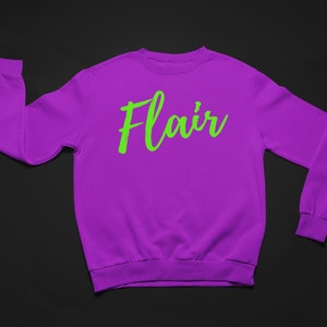 K&ouml;nnte beinhalten: Ein lilafarbener Pullover mit dem Wort "Flair" in Gr&uuml;n.