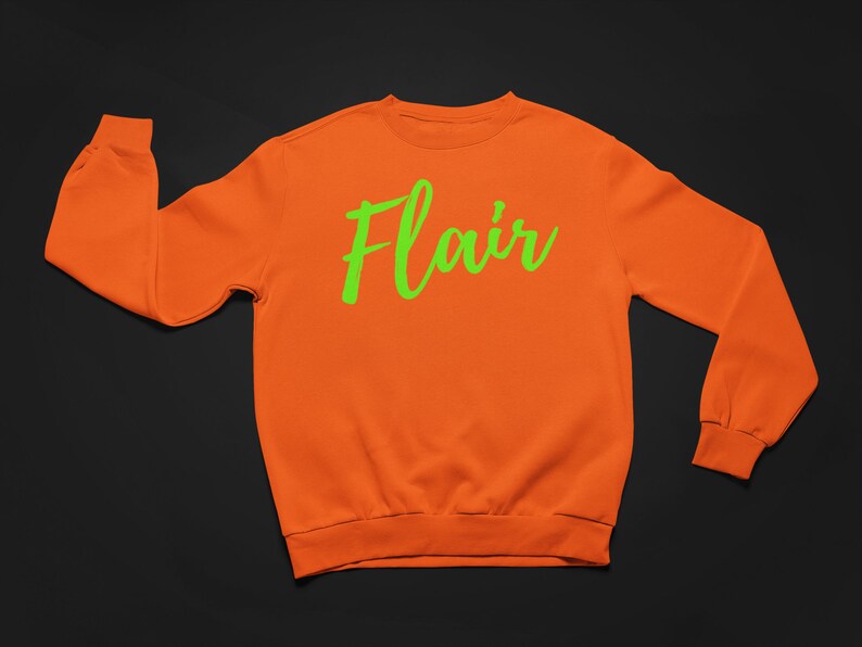 K&ouml;nnte beinhalten: Orangefarbener Pullover mit einem gr&uuml;nen "Flair"-Aufdruck auf der Vorderseite.
