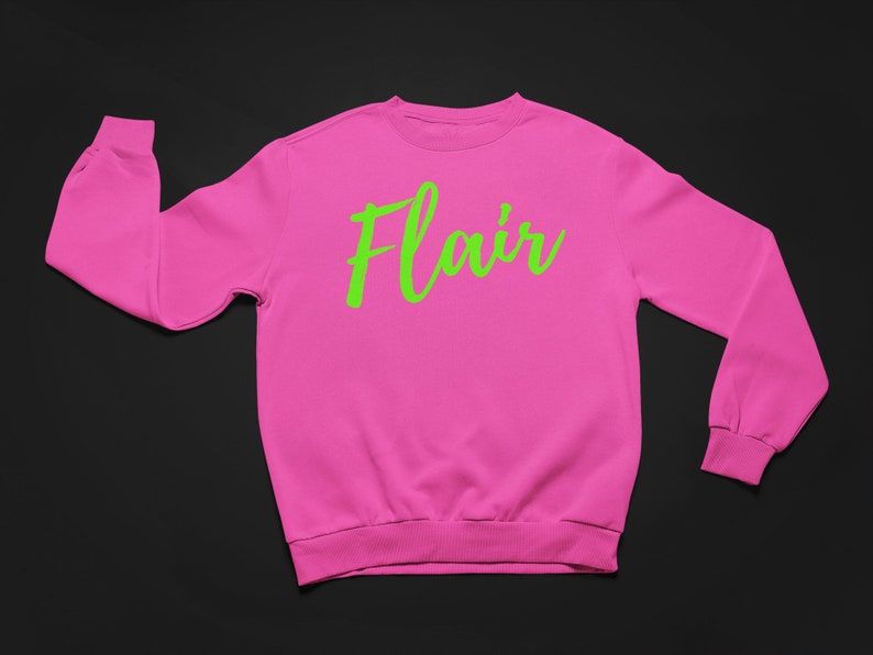 K&ouml;nnte beinhalten: Ein rosa Sweatshirt mit dem Wort "Flair" in Gr&uuml;n auf der Vorderseite.