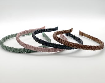 May include: Four headbands in different colors: green, pink, black, and brown. The headbands are made of a soft, stretchy material and are designed to be comfortable to wear.