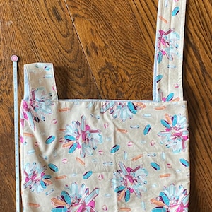 May include: A beige tote bag with a crystal pattern. The bag has a long strap and a short handle. The strap and handle are lined with white fabric. The bag is made of cotton.