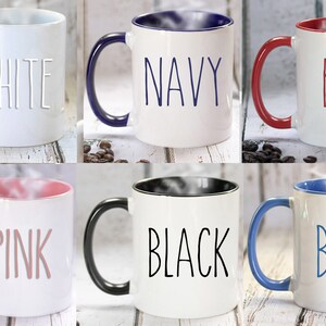 May include: Six ceramic coffee mugs with different colored rims. The mugs are white with the words "WHITE", "NAVY", "RED", "PINK", "BLACK", and "BLUE" written in black on the front of each mug.