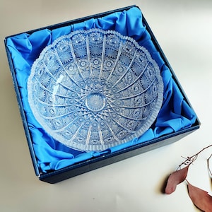 Può includere: Una ciotola di vetro trasparente con un motivo decorativo in vetro tagliato si trova in una scatola di velluto blu. La ciotola è rotonda e ha un bordo largo.