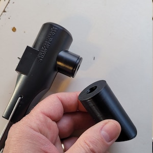 May include: A black plastic air pump nozzle with the text "REVERSE THREAD  HIGH VOLUME TRANSFER" printed on the side. The nozzle is separated from a black plastic adapter.