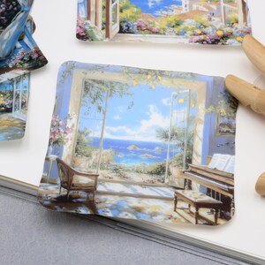 May include: A collection of square stickers featuring scenic paintings. One sticker depicts a room with a piano and a view of the ocean. Other stickers show similar scenes of landscapes and architecture, with a focus on light and color.