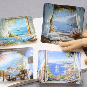 May include: Four square decorative coasters featuring scenic coastal views. Each coaster depicts a different window scene with ocean views, sailboats, and floral accents. The color palette includes blues, whites, and greens, evoking a serene atmosphere.