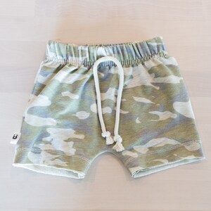 May include: Camouflage print shorts with a white drawstring. The shorts have a relaxed fit and are made of a soft, comfortable fabric.