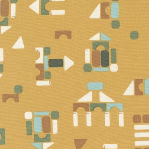 May include: A yellow fabric with a repeating pattern of colorful geometric shapes, resembling building blocks. The shapes are in shades of brown, green, blue, and white.