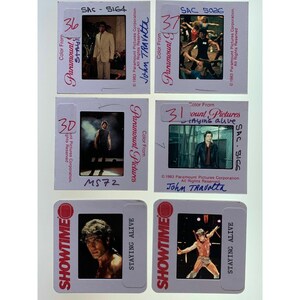 May include: A selection of vintage film slides from the film "Staying Alive." The slides feature scenes with John Travolta and are marked with the Paramount Pictures and Showtime logos. The slides are in a white frame and include handwritten text.