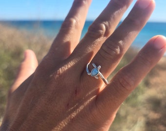 Könnte beinhalten: Ein silberner Ring mit einem weißen Opal-Stein in Form einer Schildkröte.