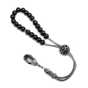 Puede incluir: Un collar de cuentas de oraci&oacute;n negro con elementos decorativos plateados. Las cuentas son redondas y espaciadas uniformemente. Los componentes plateados incluyen una cuenta decorativa, un colgante en forma de l&aacute;grima y eslabones de cadena.