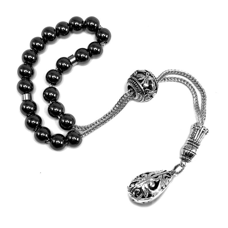 Puede incluir: Una pulsera de cuentas de oraci&oacute;n negras con un colgante decorativo de plata. Las cuentas son redondas y brillantes, conectadas por una cadena de plata. El colgante tiene un dise&ntilde;o ornamental de l&aacute;grima.