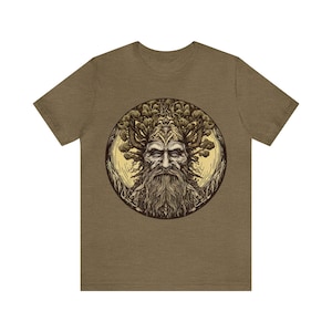 May include: A brown t-shirt featuring a detailed illustration of a bearded man with a crown of branches and leaves, set within a circular frame. The artwork has a vintage, woodcut style.