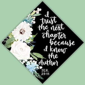 Puede incluir: Un birrete negro con letras blancas que dice "Confío en el próximo capítulo porque conozco al Autor". El birrete está decorado con detalles florales blancos y azules y el texto "JER. 29:11".