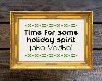 Może przedstawiać: Wzorowany haft krzyżykowy w ramie z białym tłem i czarnym tekstem, który brzmi "Time for some holiday spirit (aka Vodka)". Tekst jest otoczony obramowaniem z czerwonych i zielonych haftowanych krzyżyków.