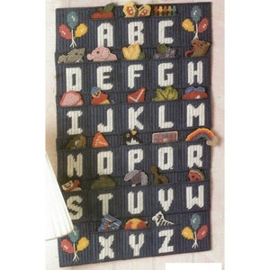 May include: A blue canvas alphabet chart with white letters and colorful pictures. Each letter has a pocket for storing small items. The letters are A-Z.