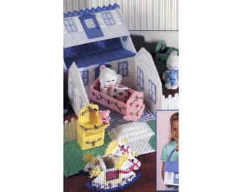 Könnte beinhalten: Ein weißes Plastik-Puppenhaus mit einem blauen Dach und einem rosa Kinderbett im Inneren. Es gibt ein Schaukelpferd, eine gelbe Kommode und einen weißen Lattenzaun. Das Puppenhaus ist von grünen und weißen Teppichen umgeben.