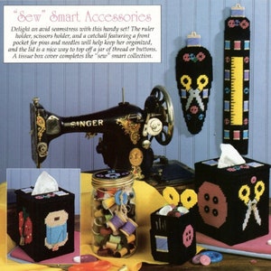 May include: A set of sewing accessories in black canvas with colorful embroidery. The set includes a ruler holder, a scissor holder, a tissue box cover, and a small jar with a lid. The accessories are decorated with sewing-themed designs, such as scissors, buttons, and thread.