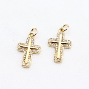 May include: Two gold-tone cross charms with clear crystal accents.