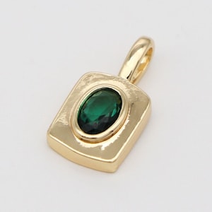 Può includere: Un ciondolo d'oro con una pietra ovale verde incastonata in una cornice quadrata.